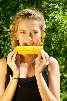 Close-up outdoor portrait of young beauty woman eating corn-cob