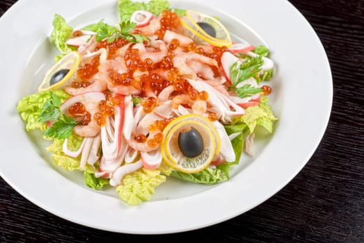 Salad with shrimps, caviar, calamaries, lettuce, lemon and olive
