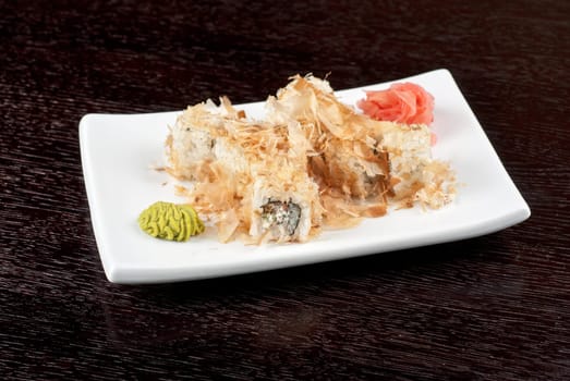 Sushi rolls of rice, nori, cream cheese, avocado, smoked salmon,cucumber and cuts of tuna