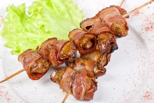 Kebab from chicken liver wrapped with bacon and garlic sauce