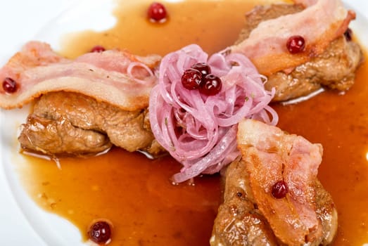 Roast pork meat with bacon, onion and cranberries