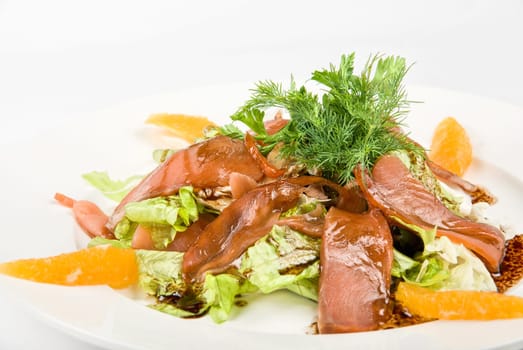 Tasty salad dish close up with fish and oranges on a white background