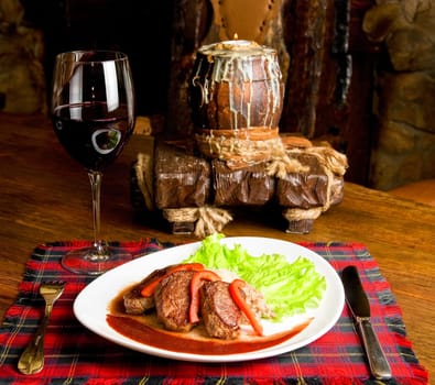 Roast maral meat with blood and garnish pearl barley at table with wine