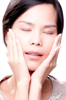 Young asian female with her hands on face in beauty shot