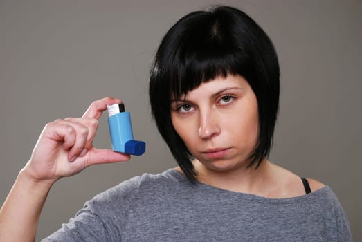 Young woman with asthma spray
