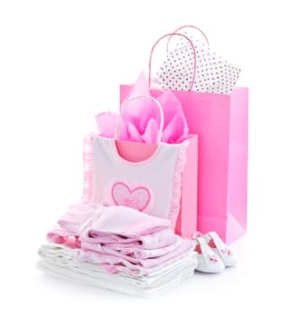 Pink gift bags and infant clothes for girl baby shower isolated on white