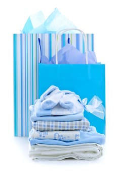 Gift bags and infant clothes for baby shower isolated on white