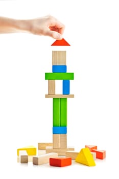 Hand building tower of wooden blocks isolated on white background