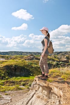 Happy female hiker looking onto the Badlands in Dinosaur provincial park, Alberta, Canada