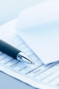Blank credit application form with envelope and pen close up