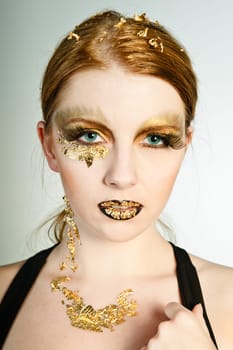 Blonde woman with leaf gold on her face