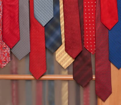 Male varicoloured ties hung on wooden door