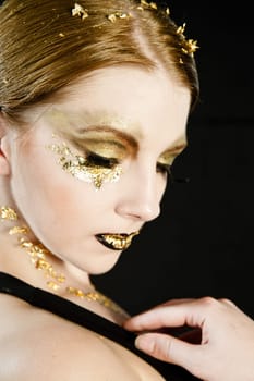 Portrait of a blonde woman with gold on her face
