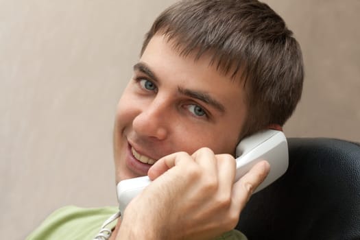 Man with telephone tube in hand smiles