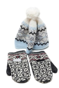 Knitted mittens and nodding on white background