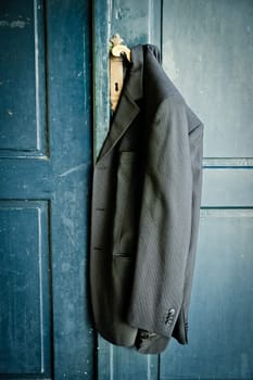 Mans coat hanging on a handle of a vintage door