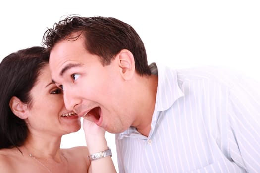 girl tells something into surprised guy&#039 s ear isolated on white background