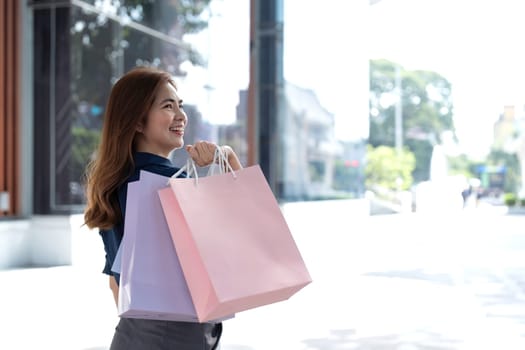 Young woman with shopping bags near mall. purchase, shopping, lifestyle, sale concept.