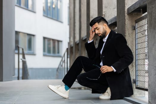 Unhappy sad Indian business man frustrated stress pensive feeling bad after company lost job unemployment problem financial crisis. Arabian Hindu freelancer guy sits at office business center building