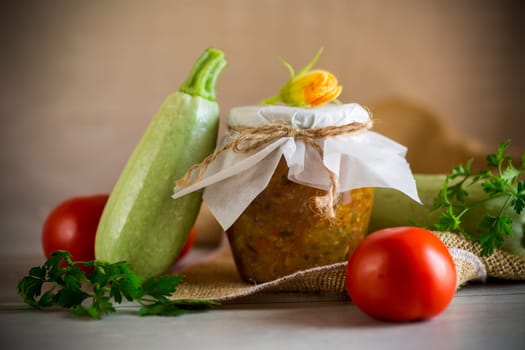 Cooked zucchini caviar with tomatoes in a glass jar, preservation.