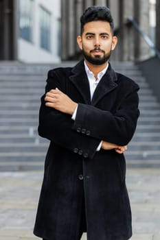 Portrait of happy Indian businessman smiling friendly, glad expression looking at camera, feel satisfied good news outdoors. Arabian Hindu freelancer in downtown city street. Business people. Vertical