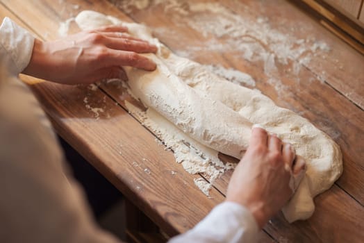 Top view of hands of a woman, working with dough, the future bread