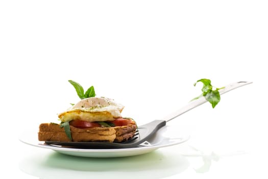 Prepared toast sandwich with fried egg with spices and herbs on a kitchen spatula.