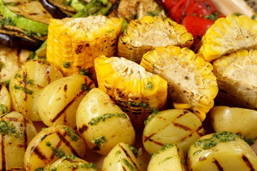 Grilled baked potatoes with corn, on a large frying pan. Food court