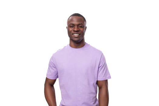 young positive american man in lilac t-shirt smiling on white background.