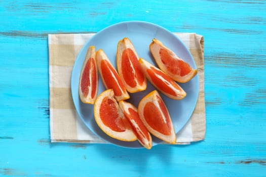 Cutting ripe grapefruit on board flat lay. Citrus fruits, making fresh juice or tropical cocktails.