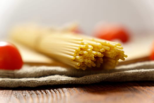 Spaghetti on a rustic background. Yellow Italian pasta. Long spaghetti. Raw spaghetti. Selective focus