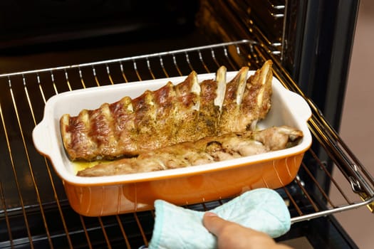 Man taking baking tray, Oven grilled spareribs on a baking. Selective focus