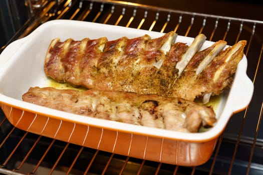 Takes pork ribs out of the oven, cooking homemade food. Selective focus.