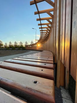 Geometrically correct angle of the bench with the sun. Wide-angle lens, geometry. Selective focus. Vertical photo