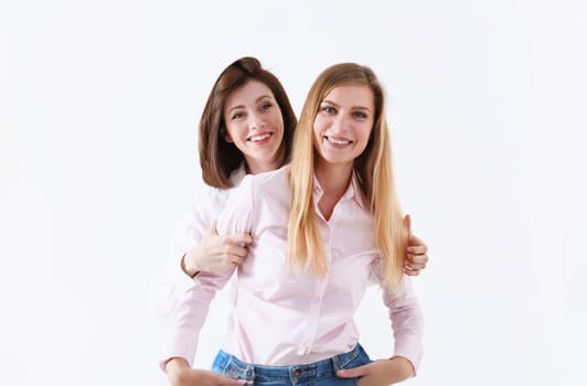 Two smiling happy joyful female friends portrait looking in camera over white background. Homosexual marriage lesbian couple love relations modern positive relationship concept