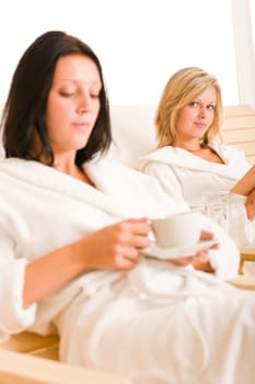 Beauty health spa treatment two women relax sun-beds coffee book