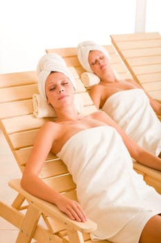 Spa luxury relax room two beautiful women lying on sun-beds