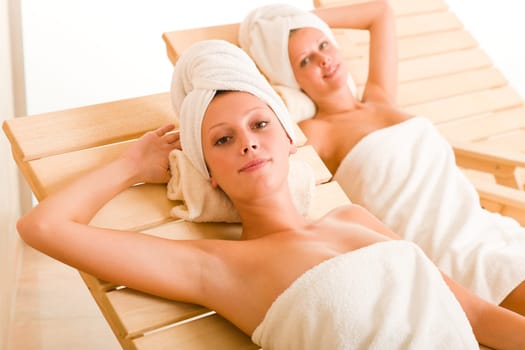 Spa luxury relax room two beautiful women lying on sun-beds