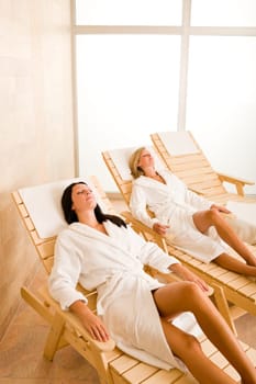 Spa luxury relax room two beautiful women lying on sun-beds