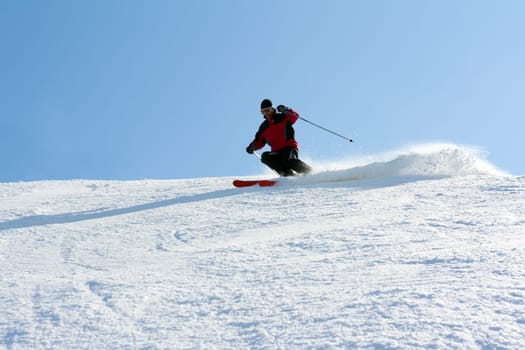 Man in red jacket goes on mountain ski