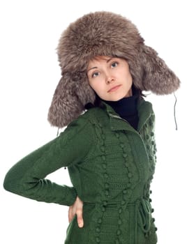 Beautiful girl in green sweater and fur hat on white background