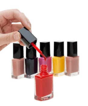 Hand with tassel and red varnish for nail on white background