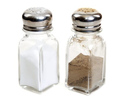 Glass saltcellar and pepper shaker on white background