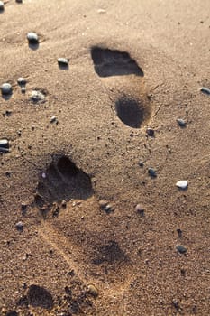 Footprints in sand. Perissa beach, Santorini, Greece