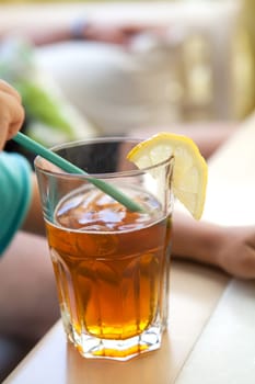 Glass of refreshing ice tea with a slice of lemon
