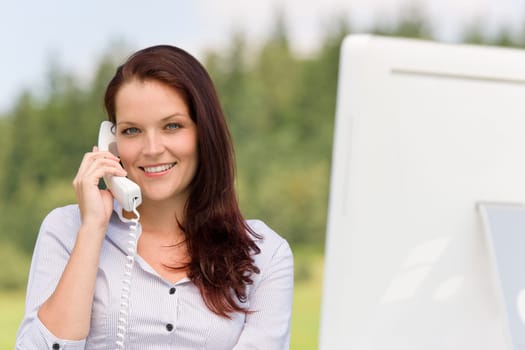 Young businesswoman in nature attractive smiling calling sitting behind table