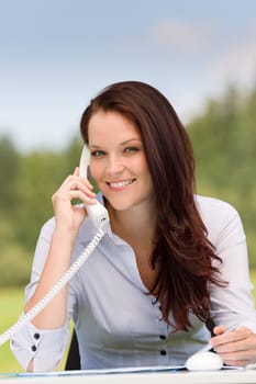 Young businesswoman in nature attractive smiling calling sitting behind table