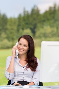 Young businesswoman in nature attractive smiling calling sitting behind table
