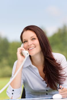 Young businesswoman in nature attractive smiling calling sitting behind table