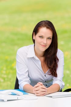 Young businesswoman in nature attractive look sitting behind table